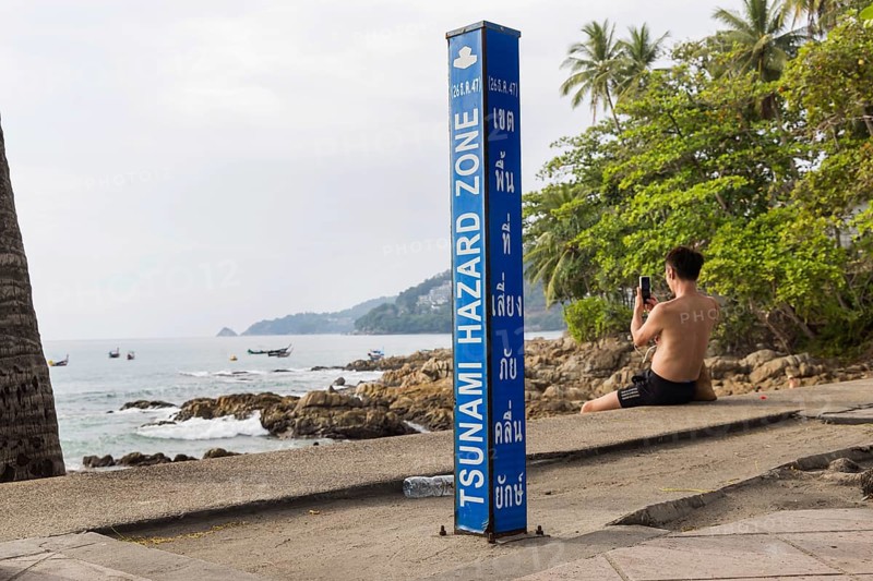 Tsunami Hazard Zone. Warning sign, signposting of escape routes in the event of another seaquake. Beach area and coastal road in the town of Patong, Kathu, Phuket Island, Thailand, Asia