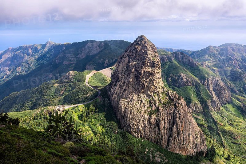 View of the Roque de Agando rock tower, one of La Gomera's landmarks, from the Mirador del Morro de Agando. During the day, sun and clouds, good weather. Monumento Natural de Los Roques, La Gomera, Canary Islands, Spain, Europe