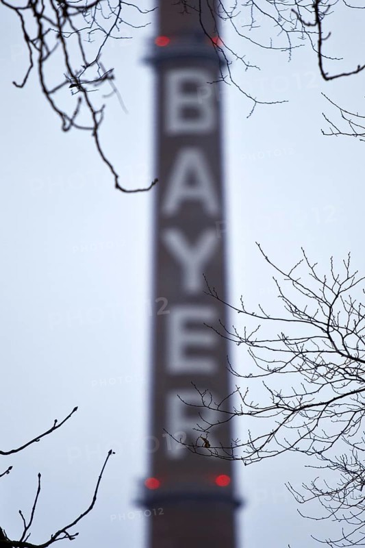 Bayer lettering on a chimney behind bare branches, Bayer AG, agrochemical and pharmaceutical company, Leverkusen, North Rhine-Westphalia, Germany, Europe