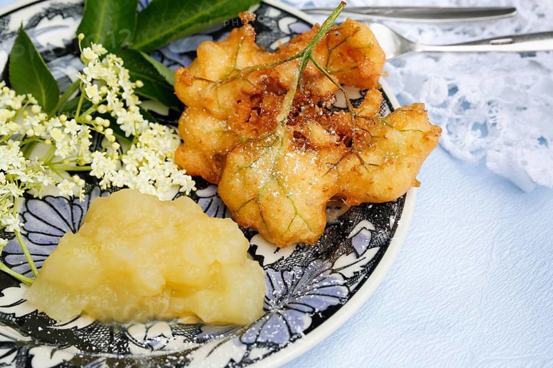 Swabian cuisine, elderberry cakes with apple sauce, Hollerkiacherl, elderflowers in pastry, dessert, dessert, fat baked, served on a plate, grandmother's kitchen, regional, home cooking, typical Swabian, classic recipe, traditional cuisine, food photography, studio, Germany, Europe
