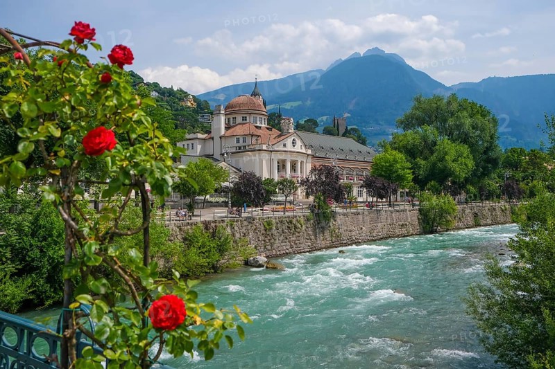 Merano, South Tyrol, Italy, spa hotel on the river Passer, on the Passer promenade in the old town centre. Red roses in front on the thermal bridge, Europe