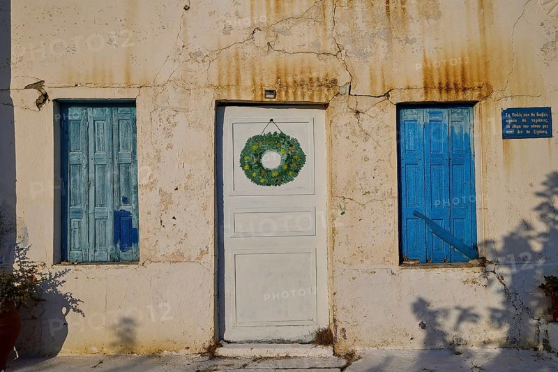 Detail of a house with blue shutters and decorated white door, Pyles village, west coast, Karpathos, Dodecanese, Greek Islands, Greece, Europe