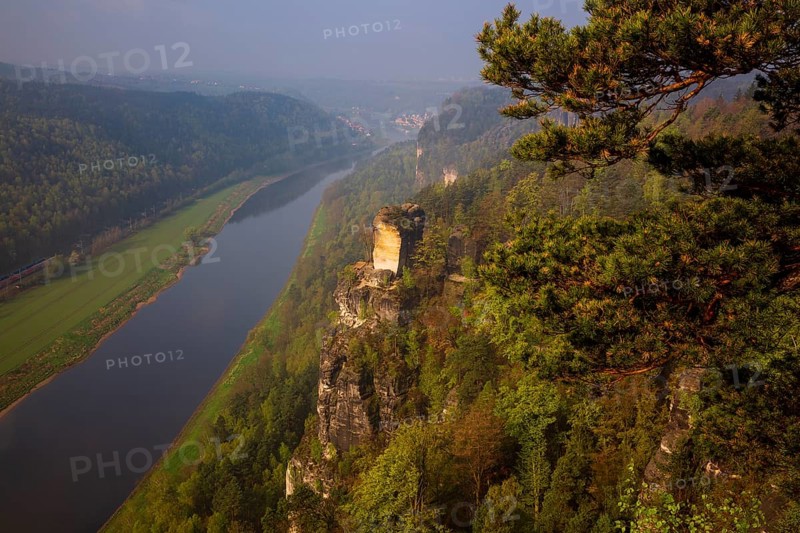 The bright lit Wartturm above the Elbe river seen from the Bastei rocks near the village of Rathen in Saxon Switzerland National Park, Saxony, Germany. On November 22, 2000 the Wartturm was the scene of a spectacular rockfall
