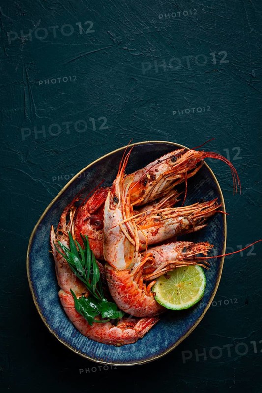 Langoustines, Australian, freshly frozen on ice, top view, lime and greens
