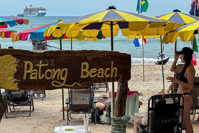 Patong beach on the Indian Ocean with parasol and cruise ship. Patong, Kathu, Phuket Island, Thailand, Asia