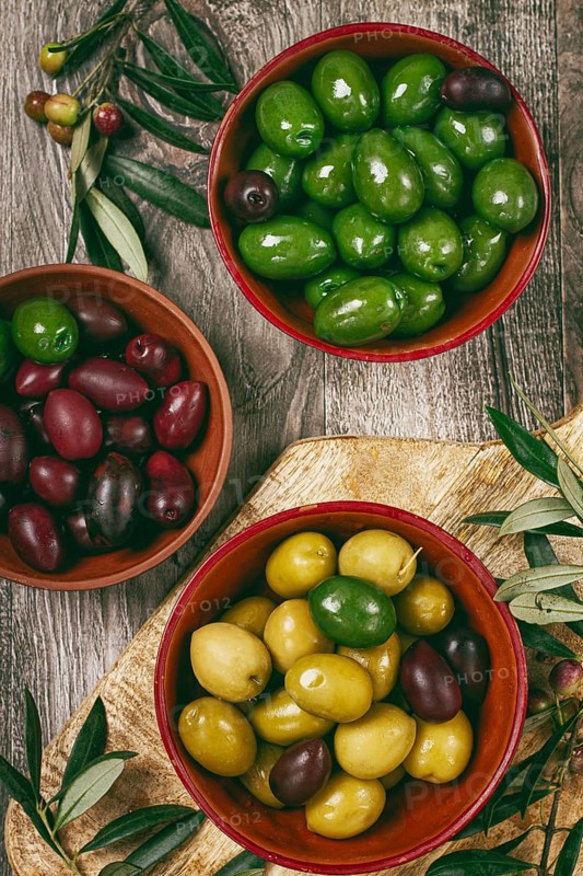 A mixture of olives, varieties of chalkidiki, Verdi giganti and Kalamata, in a bowl, top view, no people