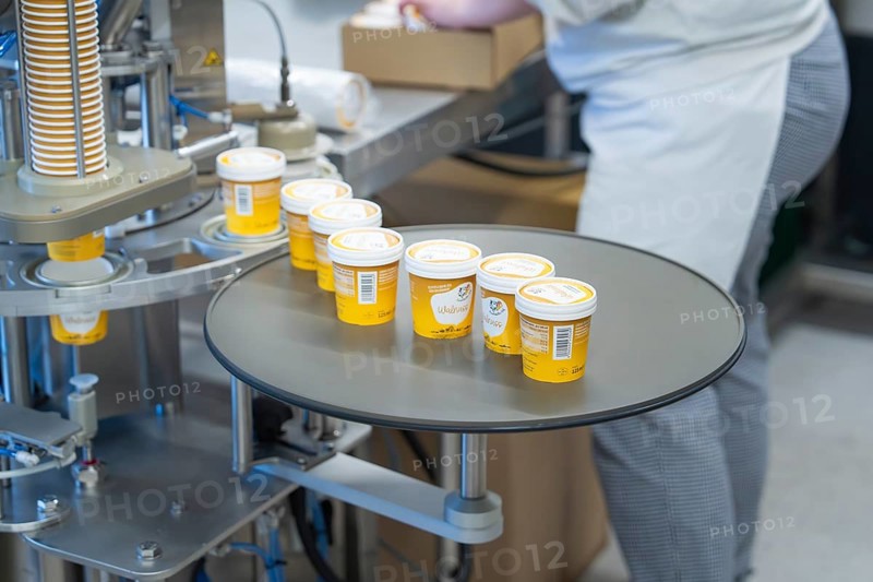 Yellow ice cream tubs on a turntable ready for packaging, ice cream production Haselstaller Hof, Calw district, Black Forest, Germany, Europe