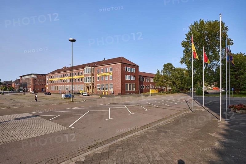 Former post office, lantern, flagpoles, car park with parking boxes, trees, blue cloudless sky, Rathausplatz and Paul-Hug-Straße, Wilhelmshaven, independent city, Lower Saxony, Germany, Europe