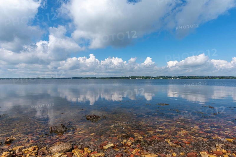 Nature reserve Holnis peninsula on the Flensburg Fjord, NSG, water reflection, German, Danish border area, blue sky, white clouds, bricks of the former brickworks on the shore, Glücksburg, Schleswig-Holstein, Germany, Europe
