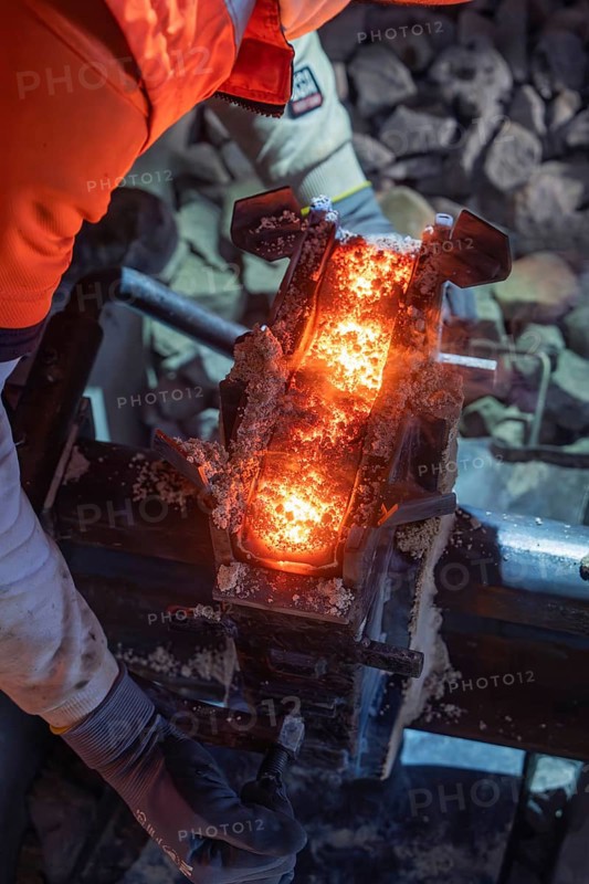 Close-up of the welding process on a rail with flying sparks and worker in the background, rail welding, track construction Hermann Hessebahn, Calw, Black Forest, Germany, Europe