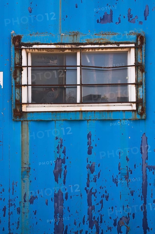 Blue painted metal building with window protected with steel bars, Quebec, Canada, North America