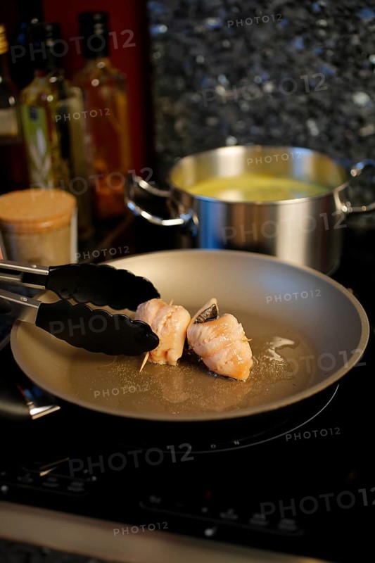 Southern German cuisine, preparation of sorrel soup with char, frying raw char fillets in a pan, oil, freshwater fish, savoury, salty, back of cooking pot with vegetable stock, cooking tongs, traditional cuisine, food photography, studio, Germany, Europe