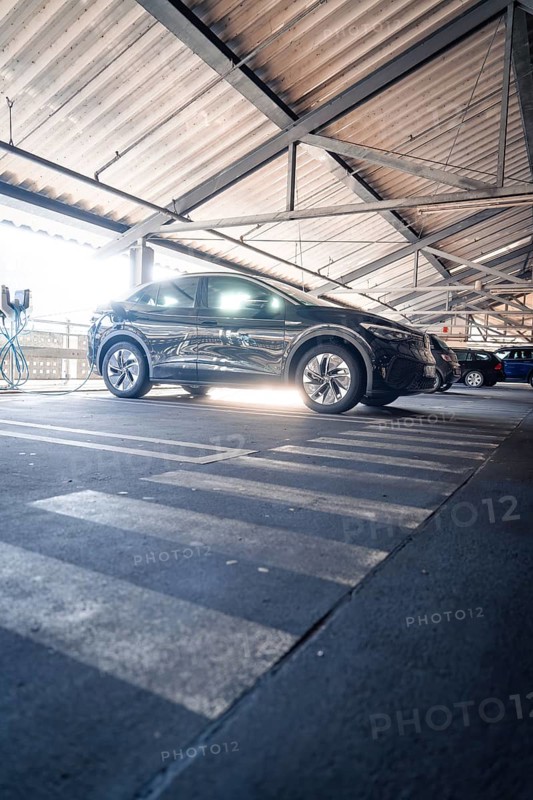 Black electric car parked under metal beams in a multi-storey car park in daylight, Kaufland Calw multi-storey car park, Calw district, Black Forest, Germany, Europe