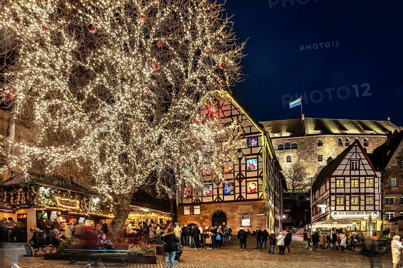Tiergärtnertorplatz with the Pilatushaus, built in 1489, a historic town house with an Advent calendar on 18 December 2024 at dusk, behind the Kaiserburg, Nuremberg, Middle Franconia, Bavaria, Germany, Europe