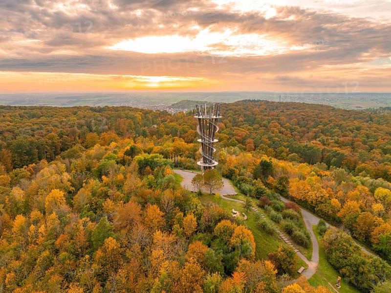 Sunlight bathes the observation tower and the surrounding autumn forest in vibrant colours, Schönbuchturm, Herrenberg, Germany, Europe