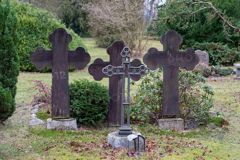 Three dark gravestones in a quiet cemetery, surrounded by bushes and bare trees, Seemannskirche Prerow, Prerow, Mecklenburg-Vorpommern, Germany, Europe
