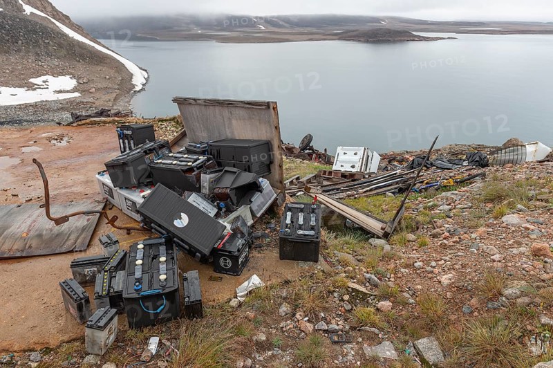 Various discarded batteries and scrap metal, Arctic settlement Ittoqqortoormiit, Scoresbysund or Scoresby Sund or Greenlandic Kangertittivaq, East Greenland, Greenland, North America