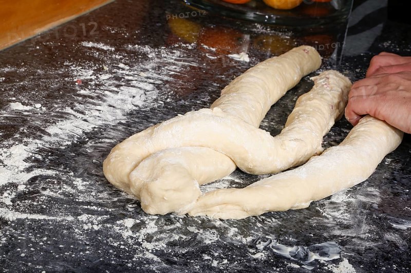Swabian cuisine, preparation of savoury yeast plait with smoked meat, salty wreath bread, yeast yeast dough pastries, plait from raw yeast dough, grandmother's kitchen, regional, home cooking, typical Swabian reinterpreted, traditional cuisine reinterpreted, men's hands, food photography, studio, Germany, Europe