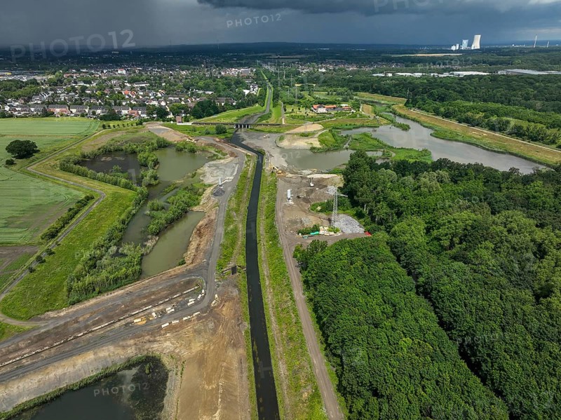 Dortmund / Castrop-Rauxel, North Rhine-Westphalia, Germany, river renaturalisation, renaturation of the Emscher, flood retention basin HRB Mengede. A new floodplain landscape is being created at the Emscher-Auen farm, expanding the area for flood protection during heavy rainfall and for biodiversity. The Emscher, which is currently straightened, will be given curves again and can meander through its new floodplain. Following the construction of a parallel sewer, the Emscher has been completely free of wastewater since 2022. The river was previously an open, above-ground mixed water channel with rainwater and wastewater. At the back right, the Uniper coal-fired power plant Datteln 4 power station, Europe