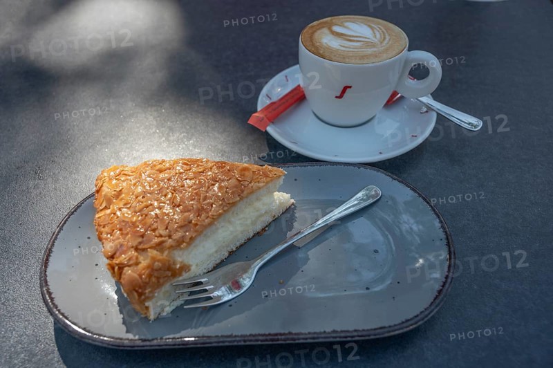 A slice of bee sting and a cup of cappuccino, on a bistro table, Bavaria, Germany, Europe