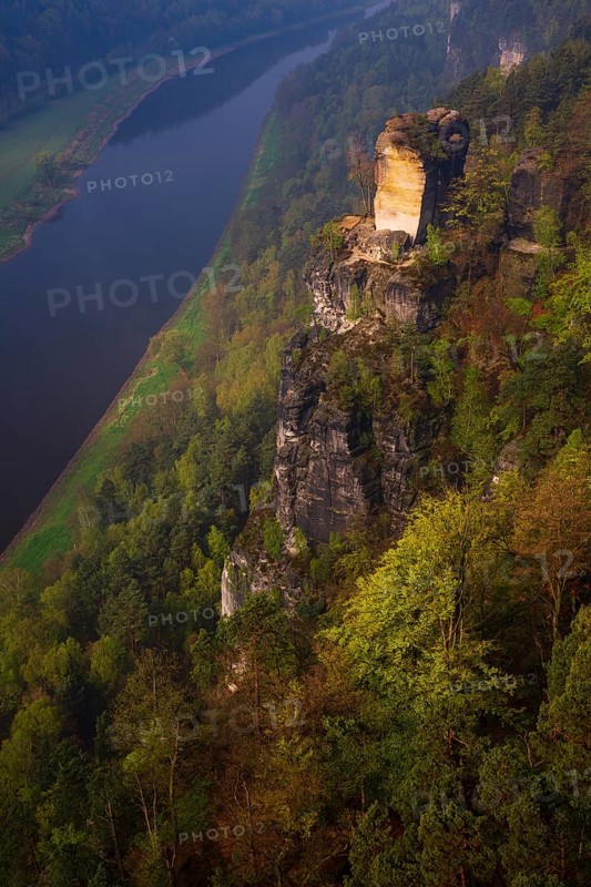 The bright lit Wartturm above the Elbe river seen from the Bastei rocks near the village of Rathen in Saxon Switzerland National Park, Saxony, Germany. On November 22, 2000 the Wartturm was the scene of a spectacular rockfall