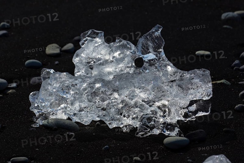 Little icebergs and crushed ice on the black beach at Joekulsarlon glacial lake