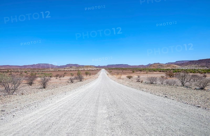 Gravel track leads through barren dry landscape with hills, Damaraland, Kunene, Namibia, Africa