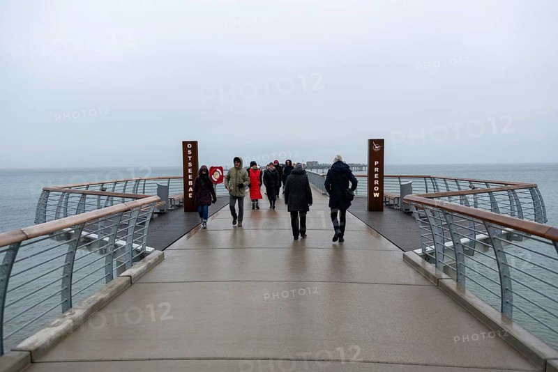 A gloomy day at a pier with several people looking towards the sea, Prerow pier, Mecklenburg-Vorpommern, Germany, Europe