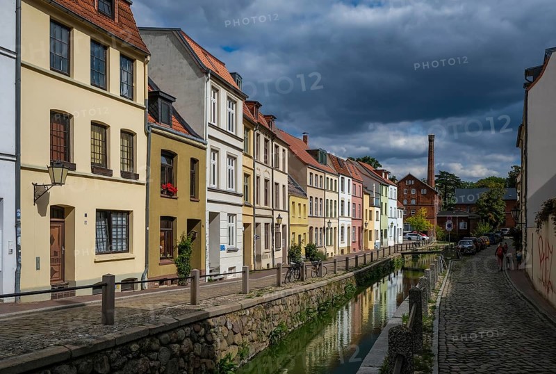 Wismar, Mecklenburg-Western Pomerania, Germany, renovated old town of the Hanseatic city of Wismar, restored colourful eaves houses at the mill pit, historic canal, streets with cobblestones, old town is an area monument of urban architecture, Unesco, world cultural heritage, in the back the old town mill, Europe
