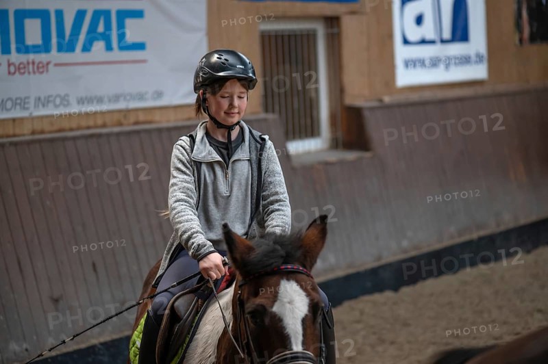 Little girl, 10 years old, in the saddle on a horse in an indoor riding arena, Mecklenburg-Vorpommern, Germany, Europe
