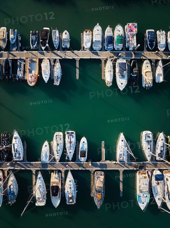 Marina with yachts aerial drone top down view. Boats and yachts moored by the pier. Cascais, Portugal on sunset