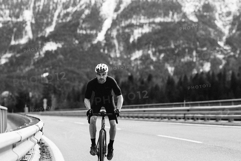 Road bike rider in spring between Lechtal and Tannheimer Tal in front of picturesque scenery of the Alps, Tyrol, Austria, Europe
