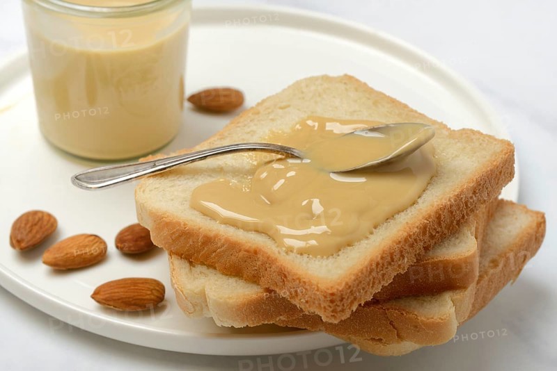 Almond cream on toast, almonds and spoon