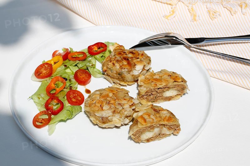 Swabian cuisine, meatballs wrapped in almonds, mixed minced meat, meatballs filled with cheese, fried, meatballs, grandmother's cooking, regional, home cooking, typical Swabian, traditional cuisine reinterpreted, served on a plate with salad, lettuce, cherry tomatoes, cocktail tomatoes, peppers, food photography, studio, Germany, Europe