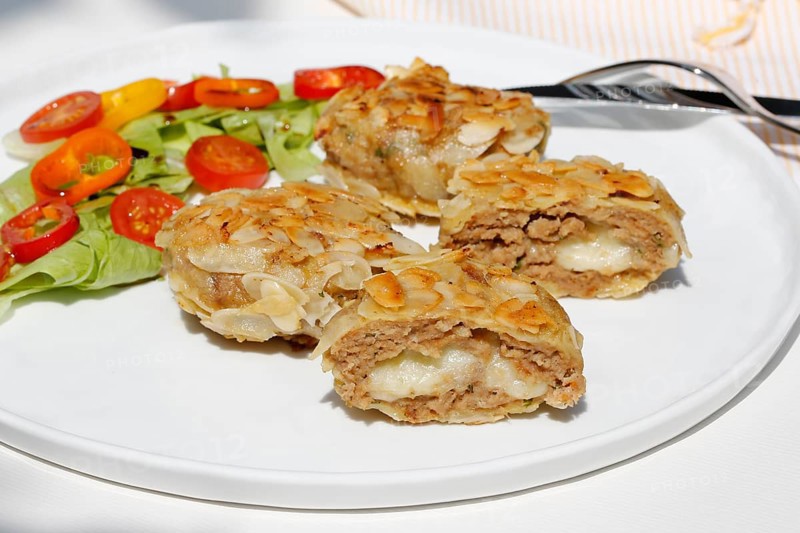 Swabian cuisine, meatballs wrapped in almonds, mixed minced meat, meatballs filled with cheese, fried, meatballs, grandmother's cooking, regional, home cooking, typical Swabian, traditional cuisine reinterpreted, served on a plate with salad, lettuce, cherry tomatoes, cocktail tomatoes, peppers, food photography, studio, Germany, Europe