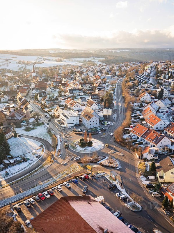 Town with snow-covered roofs and a central roundabout in winter light, Calw- Stammheim, Black Forest, Germany, Europe