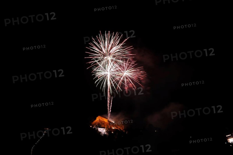 Large fireworks display glows colourfully in the night sky above an illuminated building, New Year's Eve, Stallbastei, Schlossberg, Graz, Styria