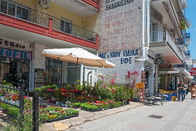 Urban street scene with shops, pedestrians and blooming flowers on a sunny day, Xanthi, Eastern Macedonia and Thrace, Greece, Europe