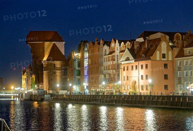 The crane gate, left, with its striking shape, built of brick and wood, in the evening-lit harbour district on the Motlawa, Motlawa, in the city centre of Gdansk. Gdansk, Pomerania, Poland, Europe