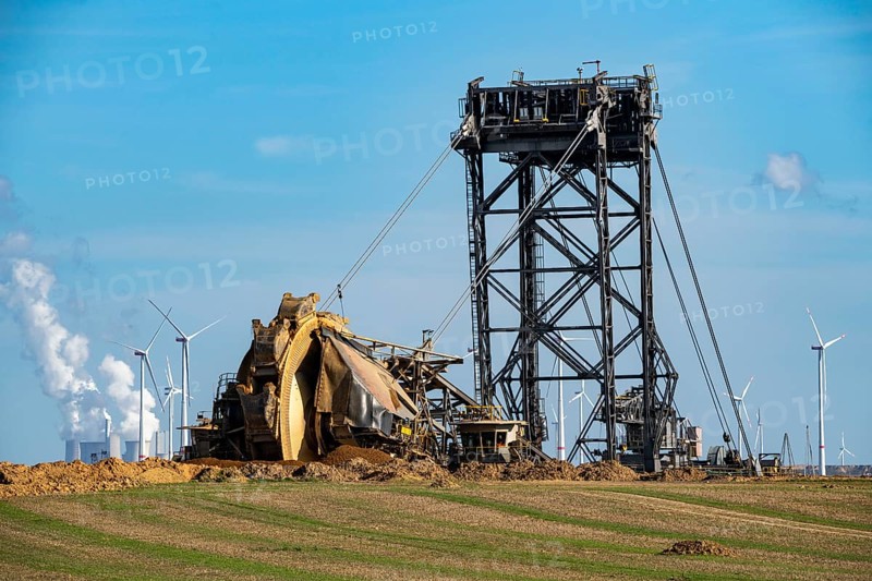 Opencast lignite mine Garzweiler II, bucket wheel excavator dredging, at the edge of the opencast mine near the village of Lützerath, belongs to Erkelenz in the district of Heinsberg, in the background wind farm, and the lignite-fired power plant Neurath, North Rhine-Westphalia, Germany, Europe