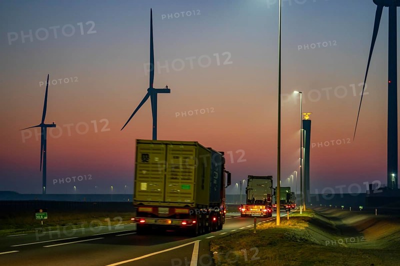 Lorry on the road from Euromax Terminal Rotterdam, ENECO wind farm on the dike around the port of Maasvlakte 2, 22 wind turbines with a capacity of 116 megawatts, sunset, Rotterdam, Netherlands