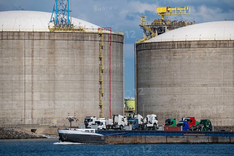 LNG import terminal tanks for liquefied natural gas in the seaport of Rotterdam, Maasvlakte, inland cargo ship, loaded with lorry tractors, Rotterdam Netherlands