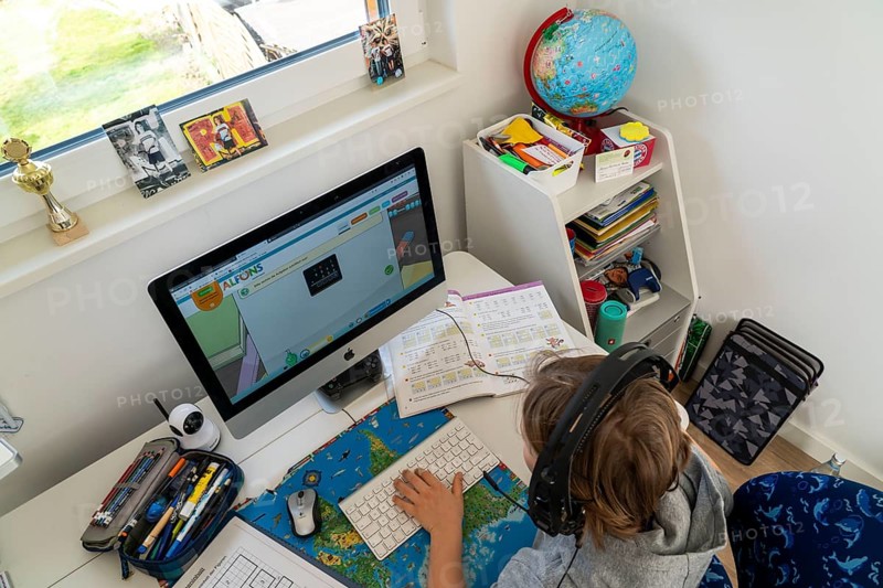 Young, primary school pupils, home learning, doing schoolwork, distance learning, virtual classroom, chat with teachers and classmates, home schooling, at home on the computer, effects of the corona crisis in Germany