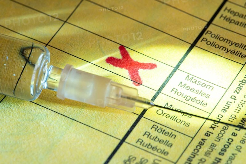 Symbolic photo measles vaccination, vaccination certificate, syringe with measles vaccine