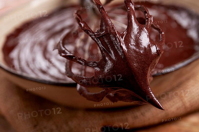 A bowl of chocolate dough, a whisk for whipping, baking, structure and consistency, homemade, top view, no people