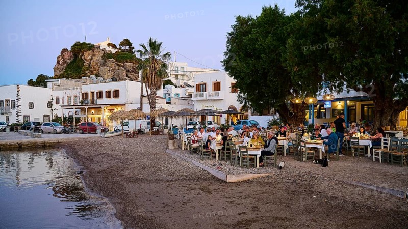 A cosy dinner on the beach, surrounded by trees and whitewashed houses, creates an atmosphere of community and peace, Skala, Patmos, Dodecanese, Greek Islands, Greece, Europe