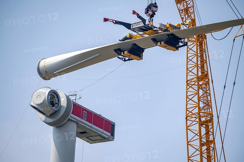 Erection of an Enercon E-160 wind turbine, rear, assembly of the first blade, 4 turbines with a total output of 22 megawatts replace 9 older wind turbines from the manufacturer Enercon (E-58 model series), front, they were in operation for over two decades, Lower Rhine, North Rhine-Westphalia, Germany, Europe