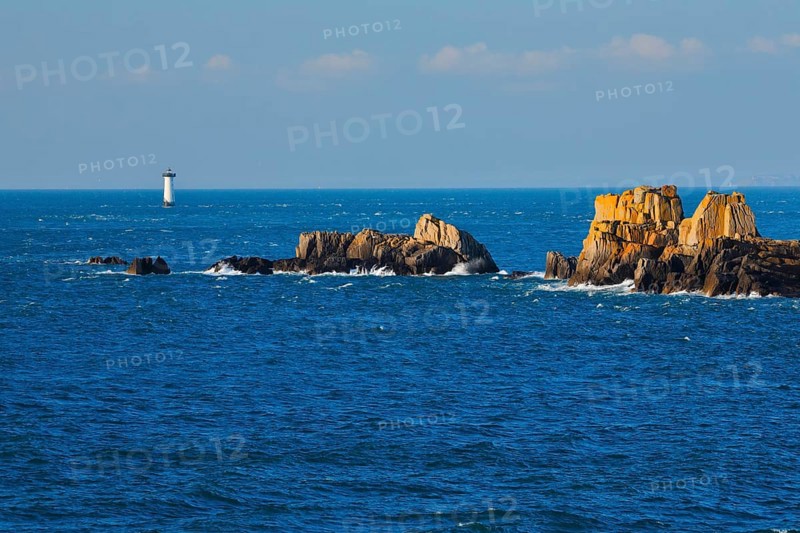Evening view from the Pointe du Grouin with a view of the Phare de la Pierre-de-Herpin and striking rocks in the water, near Cancale in northern Brittany, France, Europe