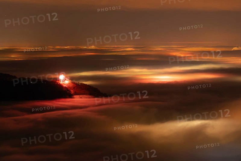 New Year's Eve fireworks 2024 on the Breitenstein, Swabian Alb near Ochsenwang. Sea of fog in the foothills of the Alb. View towards Stuttgart. In the foreground, the Hörnle near Teck looks out of the fog