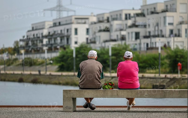 Gelsenkirchen, North Rhine-Westphalia, Germany, Senior citizens sitting on a park bench at the marina in the new Graf Bismarck city quarter, new-build flat block, site of the former Graf Bismarck colliery, on the Rhine-Herne Canal in the Gelsenkirchen Bismarck district, Europe